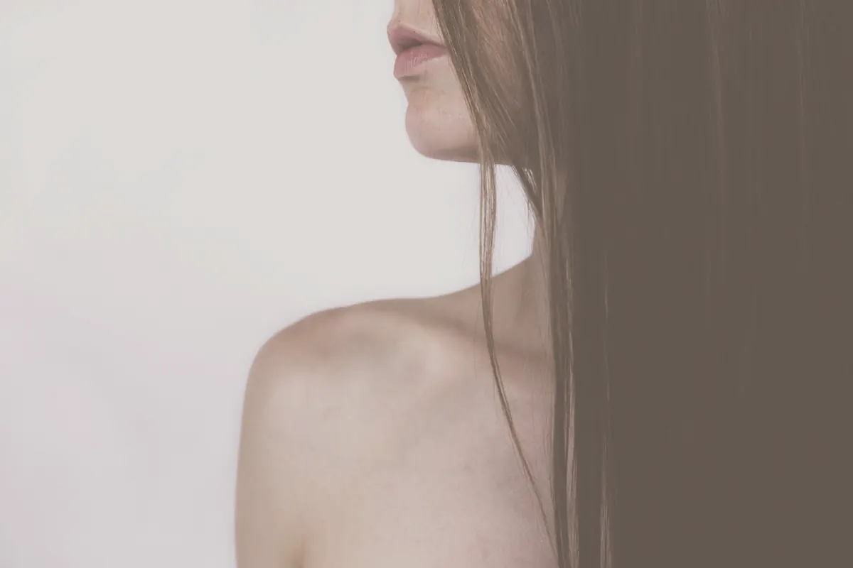 Long dark hair over a bare shoulder