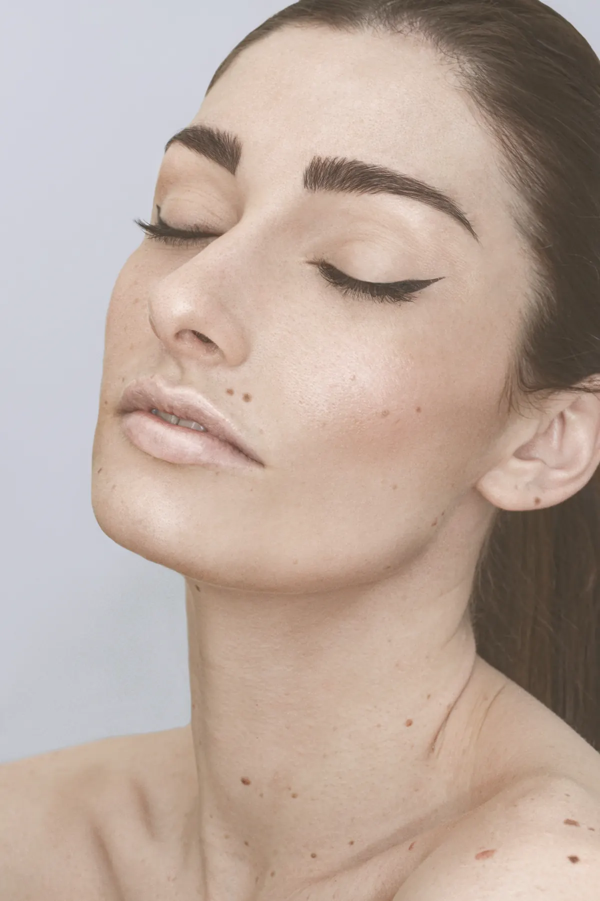 A woman with her eyes closed, in soft light